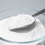 Çinko oksit tozu – beyaz ince mineral hammadde, cam kapta ve kaşıkla yakın çekim